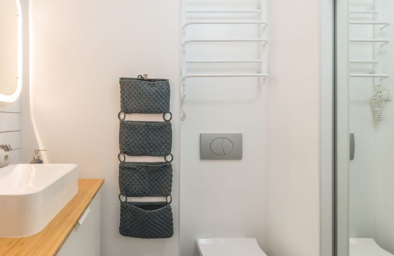 Small modern bathroom with a white toilet showing where the flapper sits inside the tank