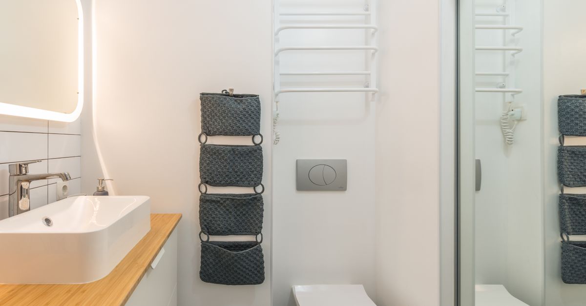 Small modern bathroom with a white toilet showing where the flapper sits inside the tank