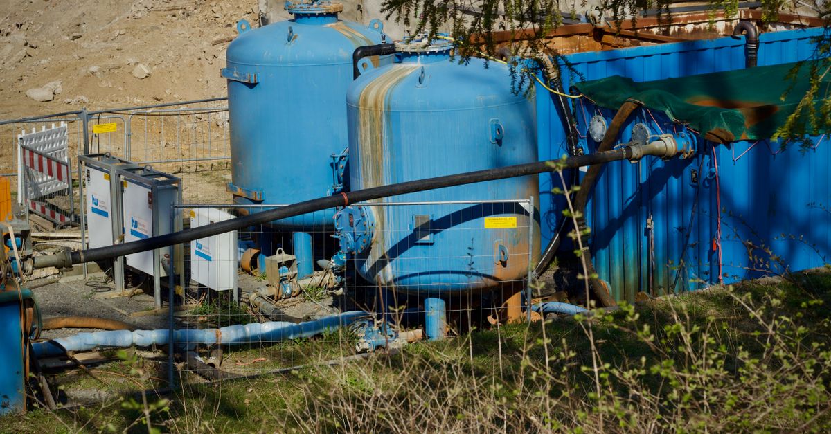 Large mineral tanks and blue plumbing at a water treatment installation representing softener regeneration hardware